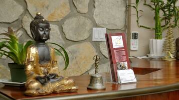 Ein Empfangsschalter mit Buddha-Statue, einer Glocke und Informationsbroschüren.