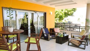 A balcony with a dining area, chairs, and a table. - Allamanda Hotel (Petionville)