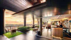 A modern bar area with a view of the city skyline at sunset, featuring wooden flooring, bar stools, and a bar counter. - Carlton City Hotel Singapore (Singapore)