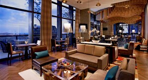 A modern hotel lobby with a large seating area, a bar, and a view of the cityscape. - Carlton City Hotel Singapore (Singapore)