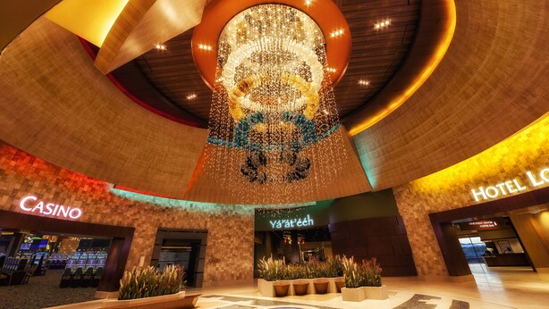 Un vestíbulo con una gran lámpara de araña, un casino y un hotel.