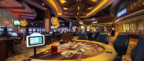 A casino with multiple gaming tables, a cashier area, and slot machines.