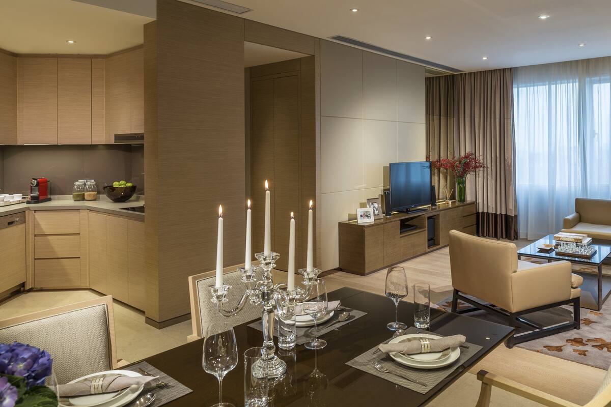 Ett modernt hotellrum med matplats, vardagsrum och kök.
