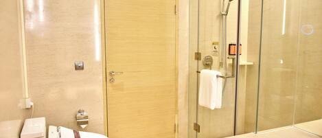 A modern bathroom with a toilet, a glass-enclosed shower, and a bathtub.