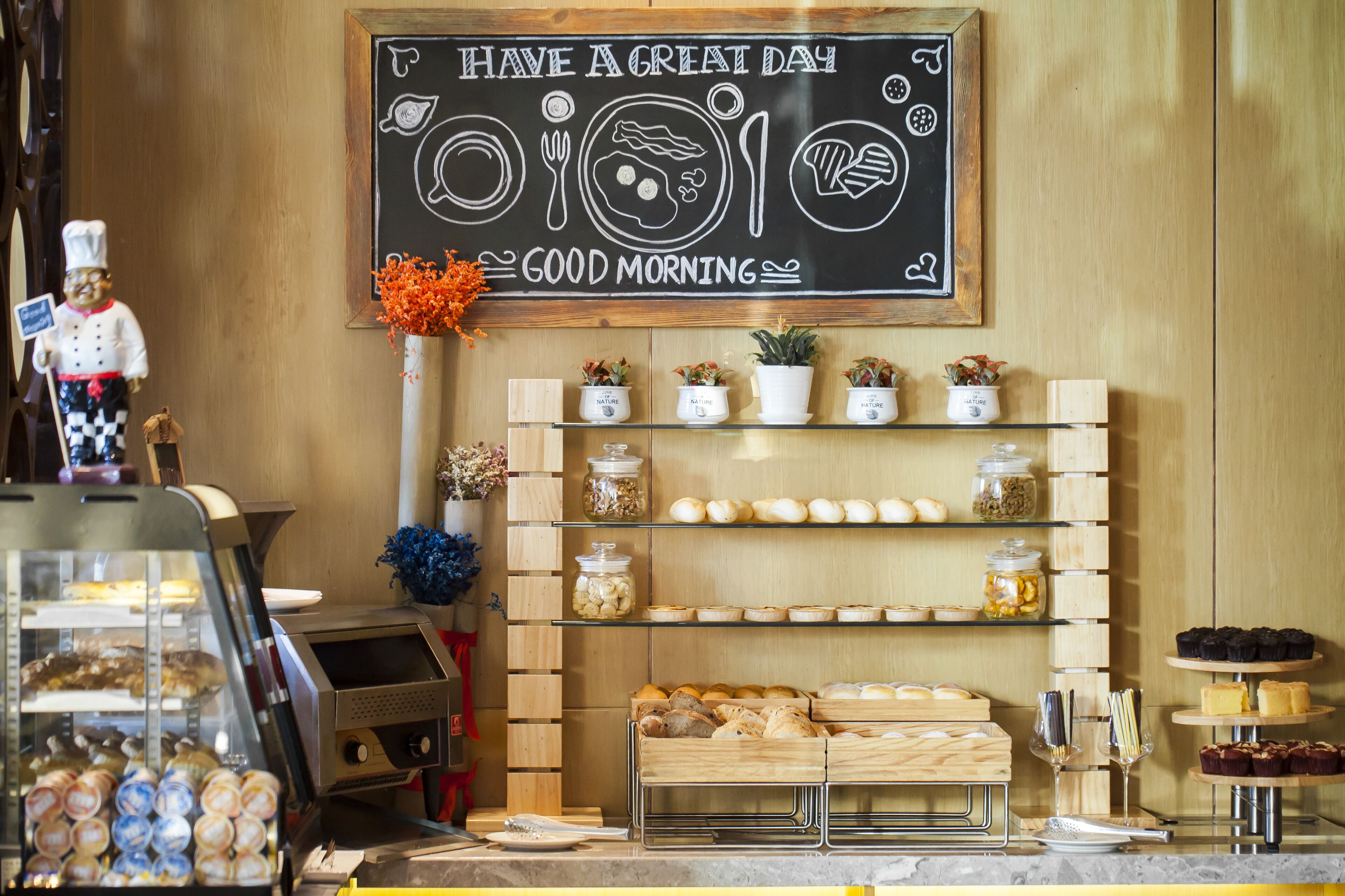 A bakery display with various baked goods and a chalkboard sign saying "Have a great day, Good morning".