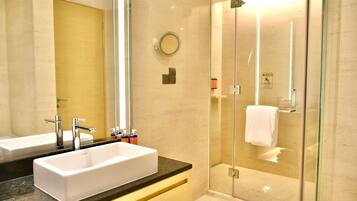 A modern bathroom with a large mirror, two sinks, and a glass-enclosed shower.