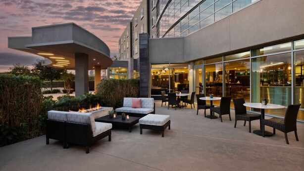 Un espace extérieur aménagé avec des canapés, des tables et un foyer.