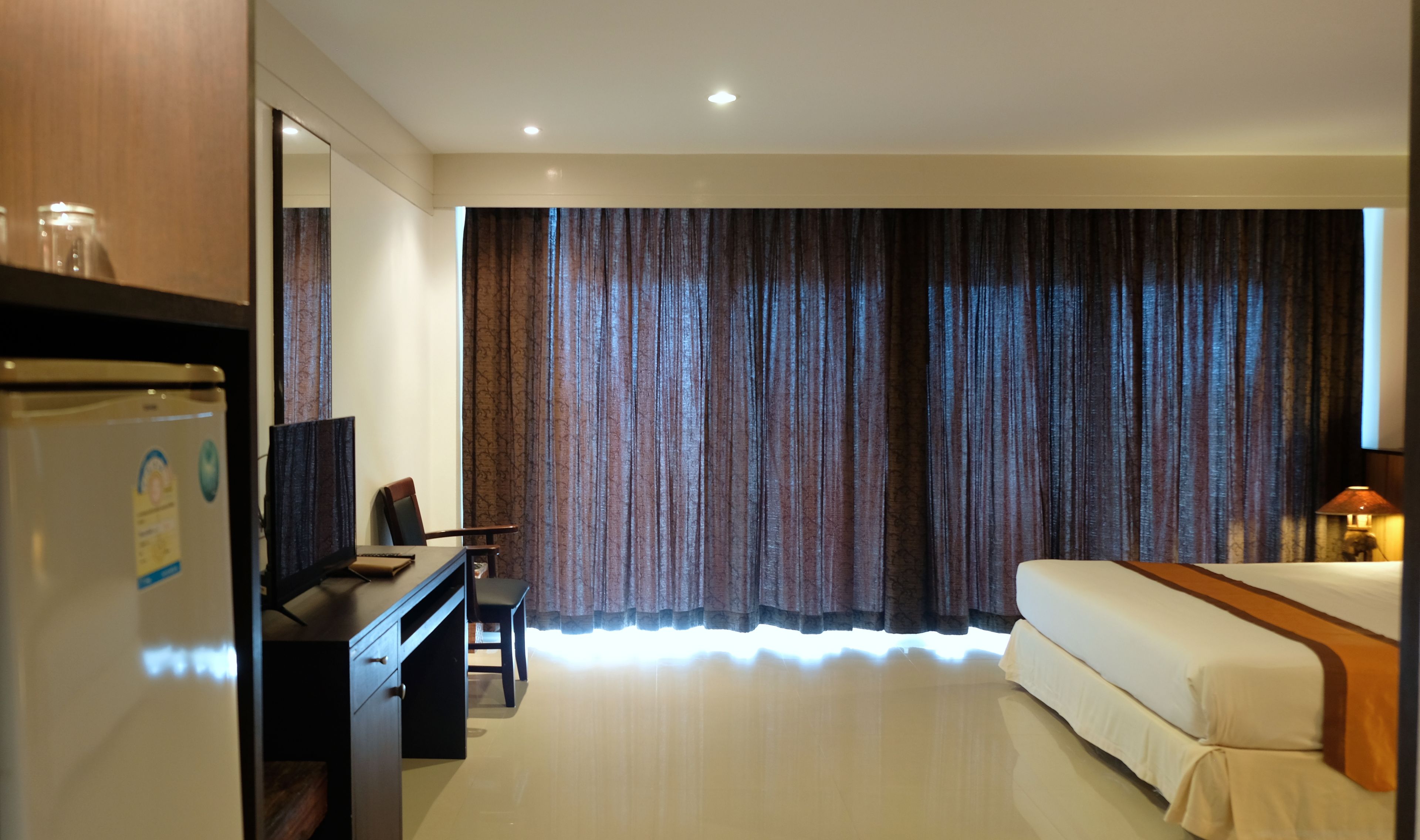 Une chambre d’hôtel équipée d’un lit, d’un bureau, d’une chaise, d’une télévision et d’une armoire.