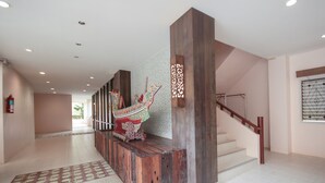 Ein modernes Interieur mit einer Holztreppe, einer Wanddekoration und einem gemusterten Teppich.