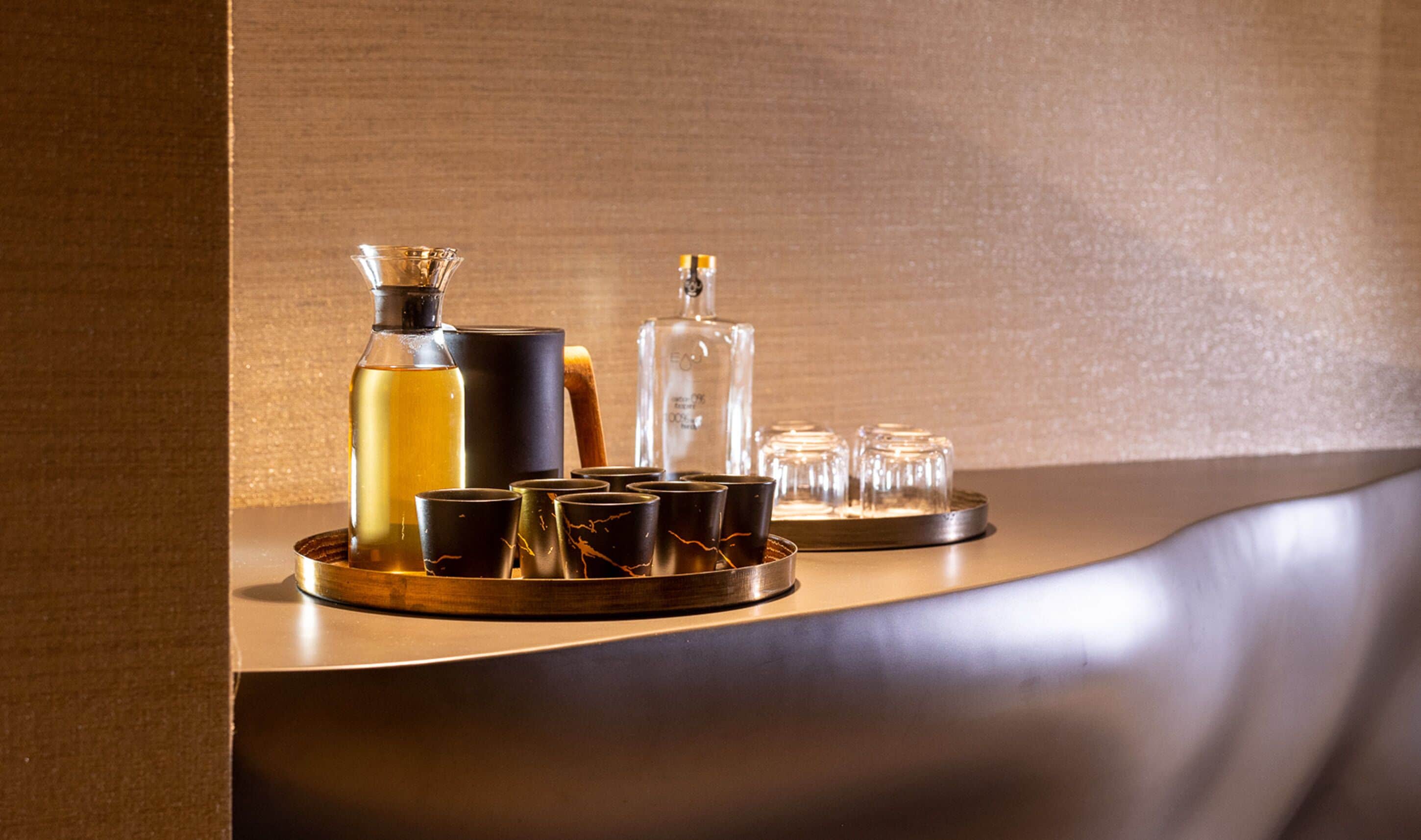 A tray with various glass containers and a bottle, likely for beverages, on a wooden surface.
