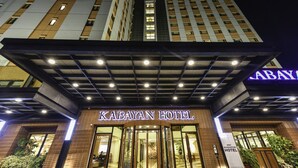 Exterior de l'Hotel Kabayan amb una entrada destacada, una zona d'entrada coberta i un senyal que indica que l'hotel no ofereix garanties.