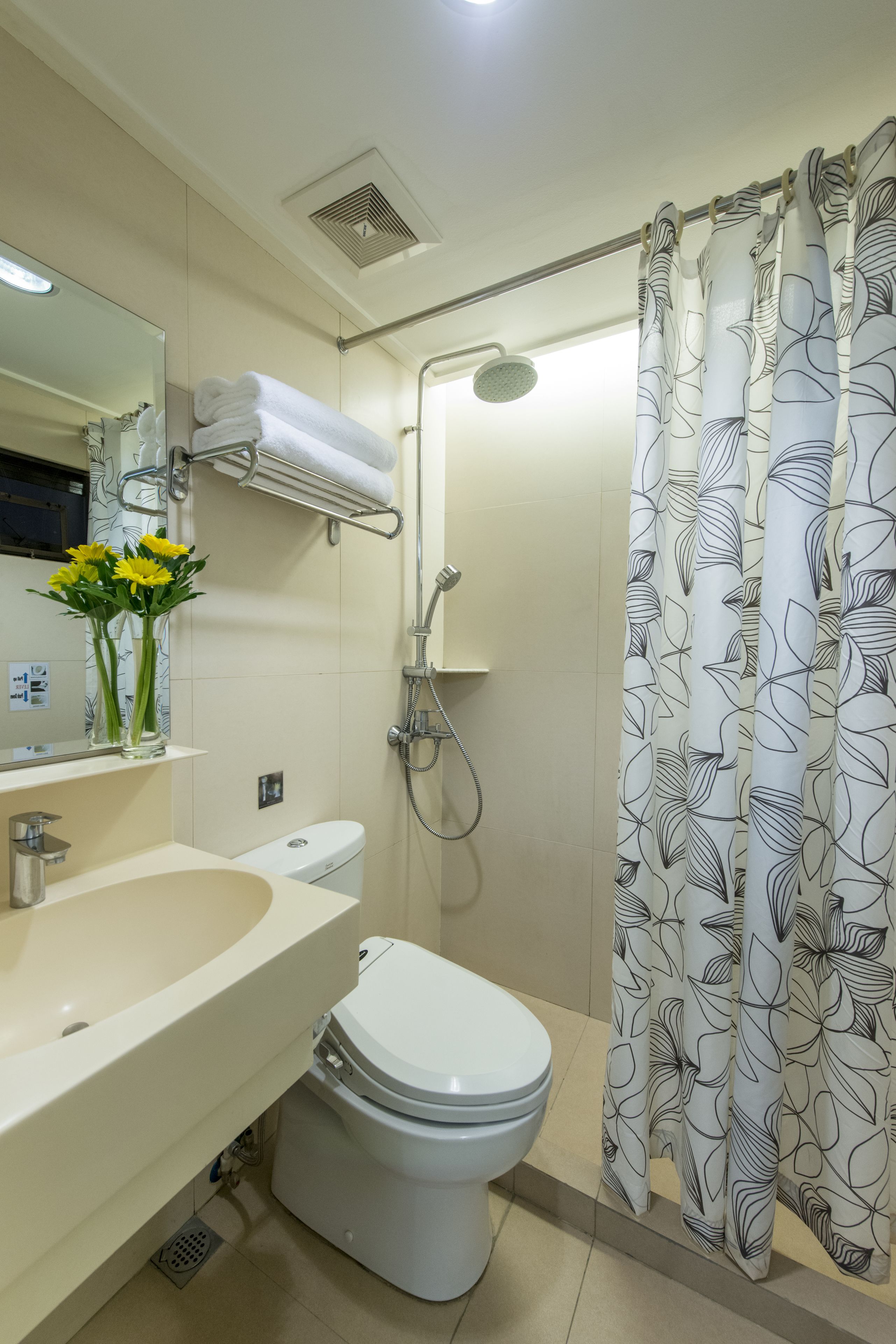 Un baño con inodoro, lavamanos, espejo y ducha.