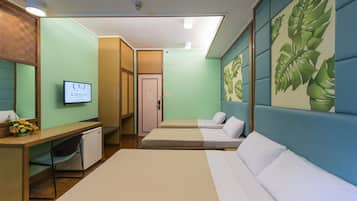 Una camera d'albergo con un letto, una scrivania con una sedia, un angolo cottura e una televisione.