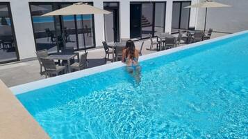 Seasonal outdoor pool, open 9:00 AM to 8:00 PM, pool umbrellas