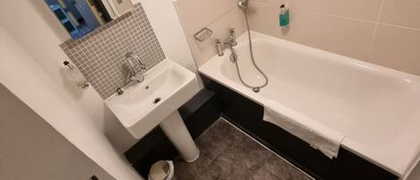 A small bathroom with a toilet, sink, and bathtub.