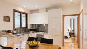 Eine moderne Küche mit weißen Schränken, Edelstahlgeräten und einem Holzespeisetisch mit einer Zitronenschale.