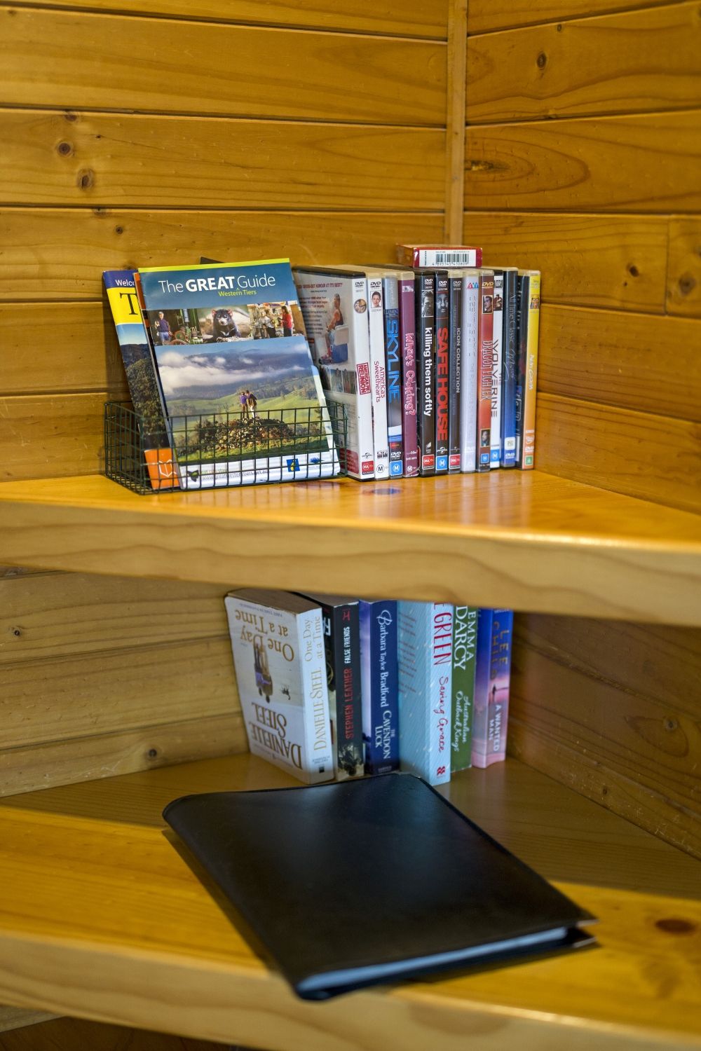 A bookshelf with a variety of books and DVDs, including titles like 'The GREAT Guide' and 'SKILLING THEM SOFTLY'.