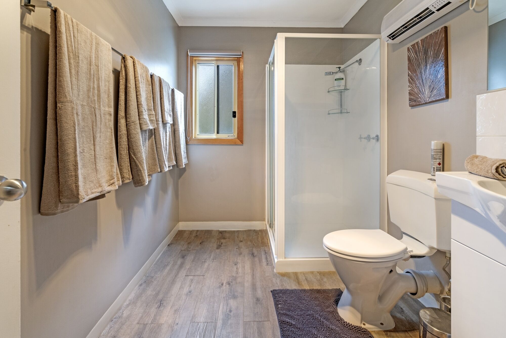 Un baño con inodoro, ducha y ventana.