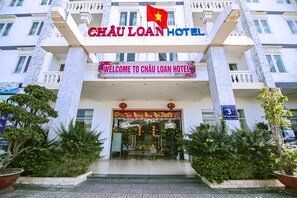 L'entrée de l'hôtel Châu Loan, avec une pancarte accueillante et un drapeau.