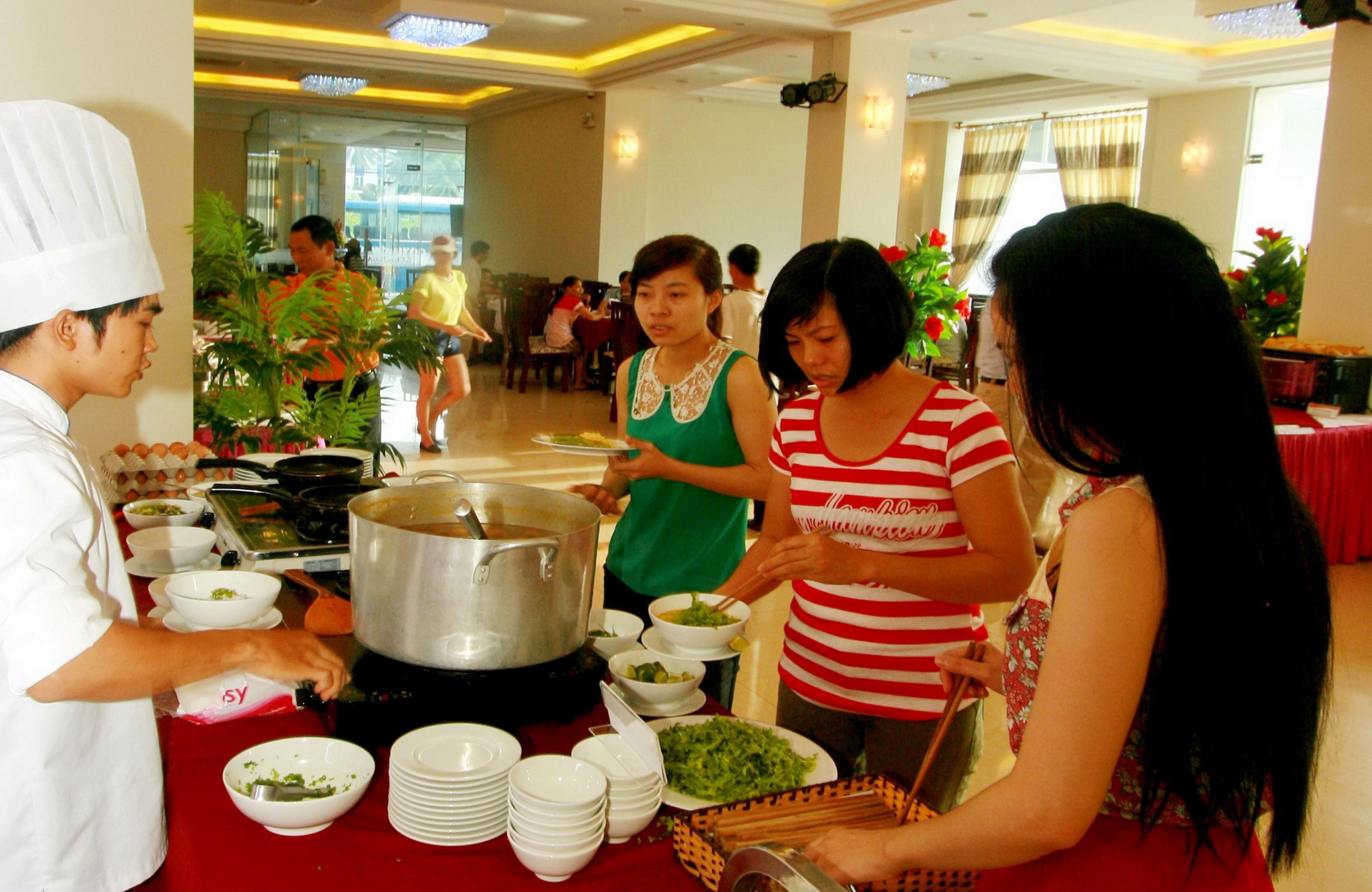 A buffet setup with multiple dishes and a large pot on the table.