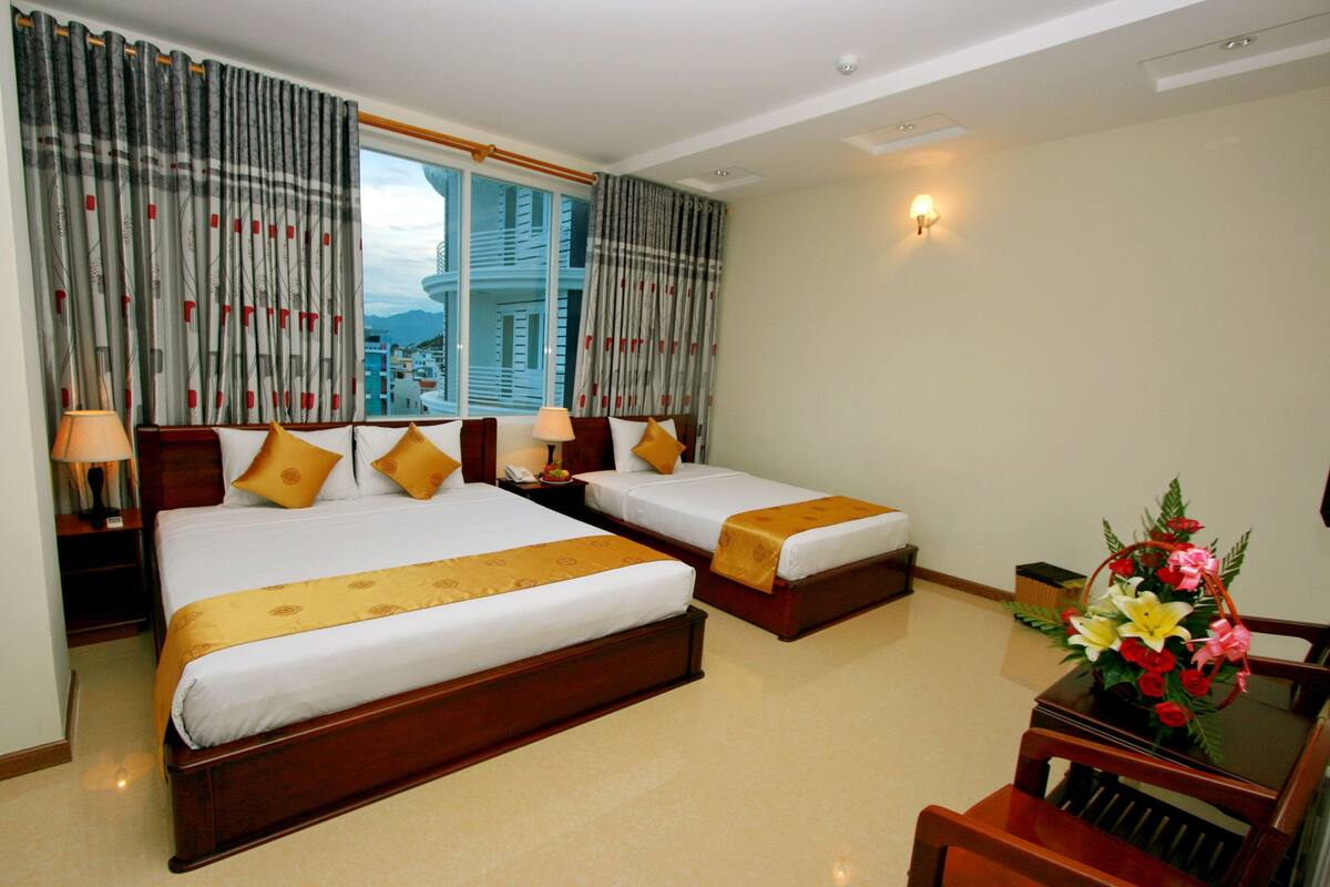 Ein Hotelzimmer mit zwei Betten, einem Schreibtisch und einem Stuhl.