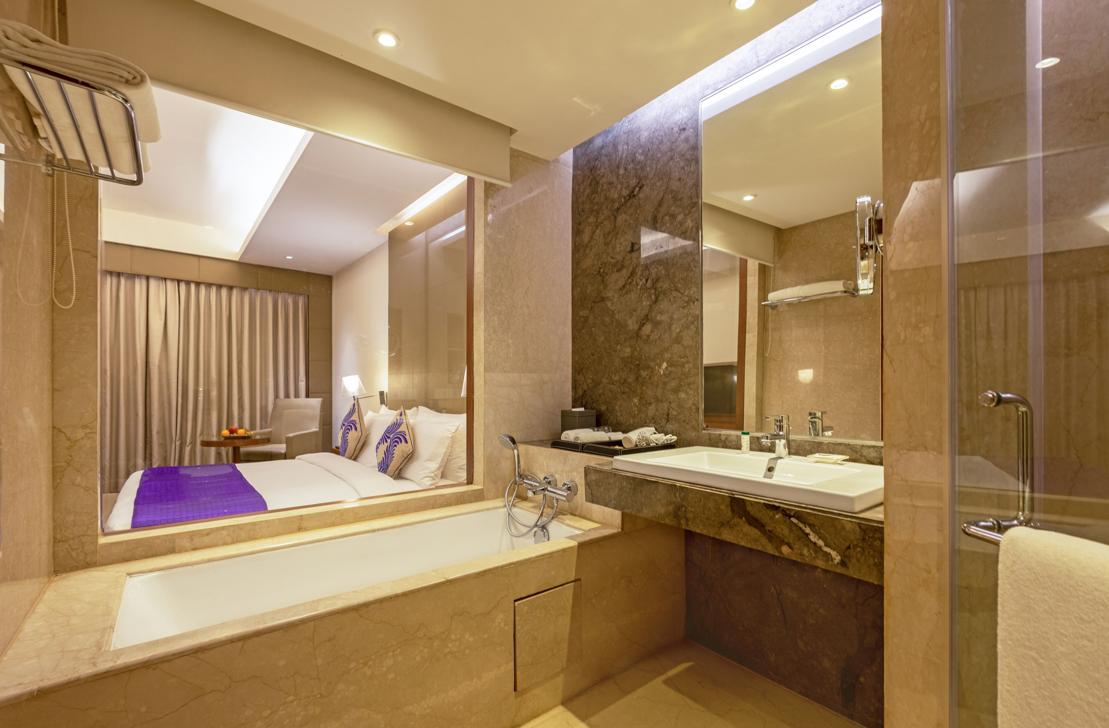 Un baño moderno con un espejo grande, una bañera y una zona de ducha.