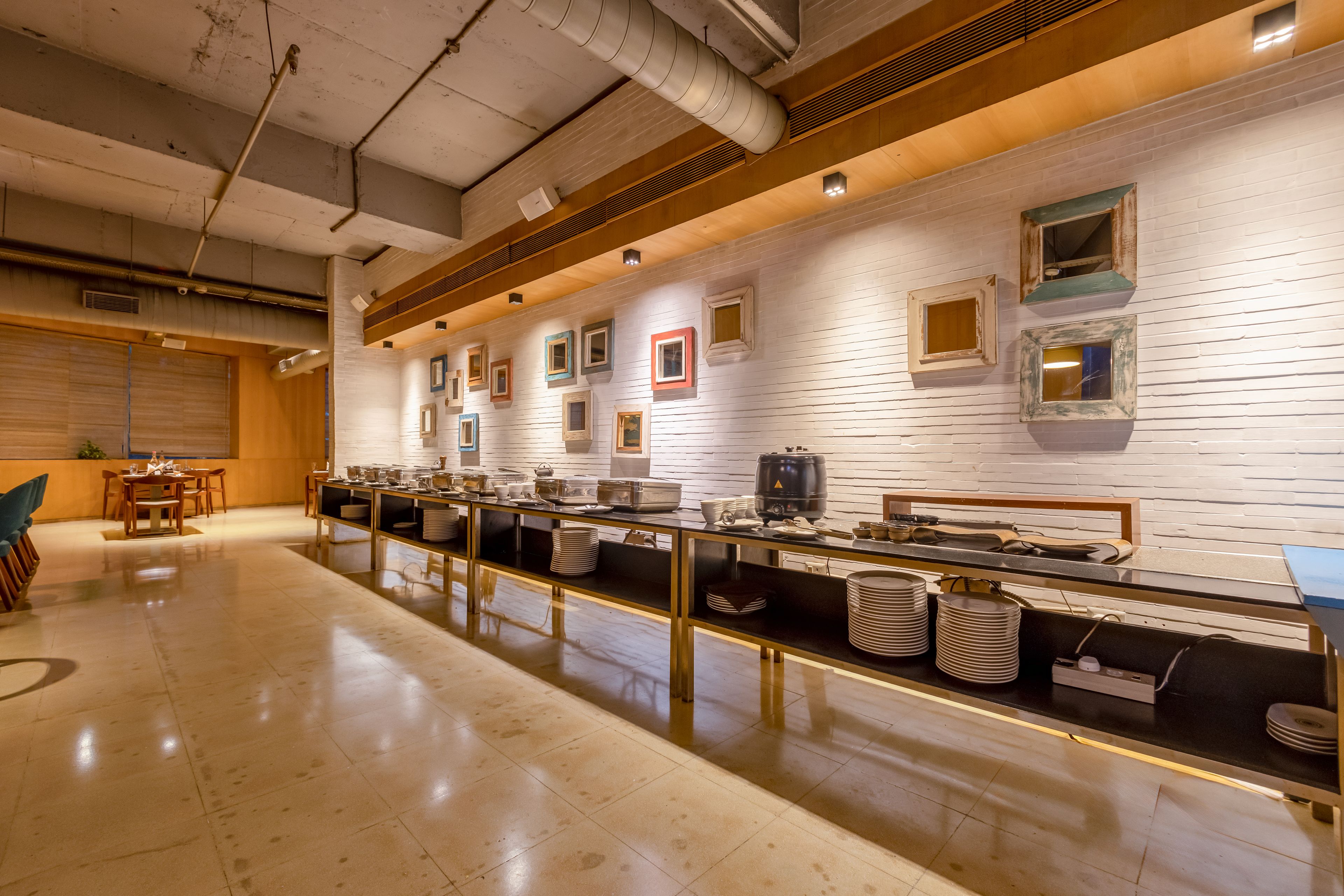 A buffet setup with a long counter, multiple serving stations, and a clean, tiled floor.