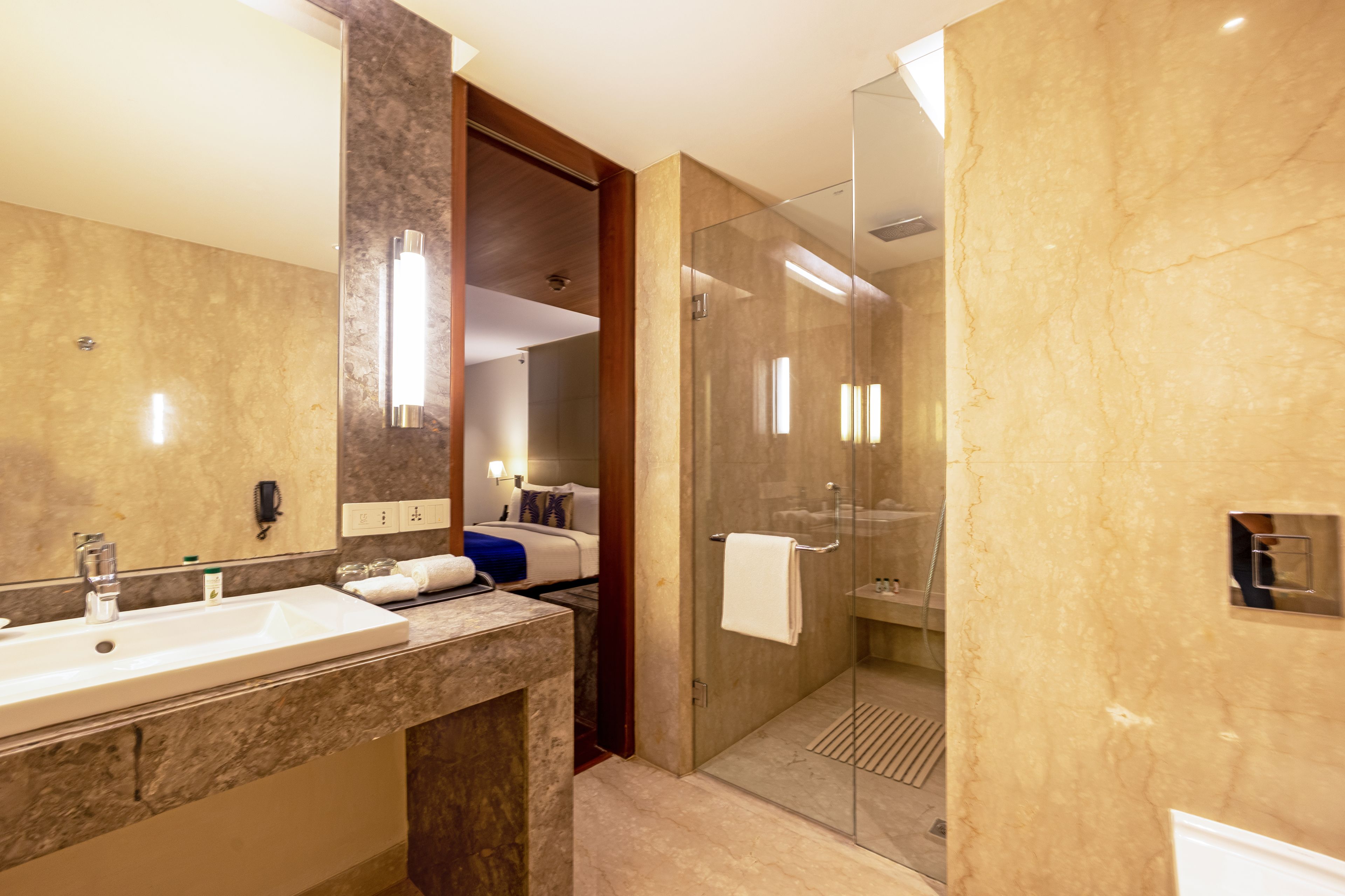 A modern bathroom with a large mirror, a sink, and a glass-enclosed shower area.