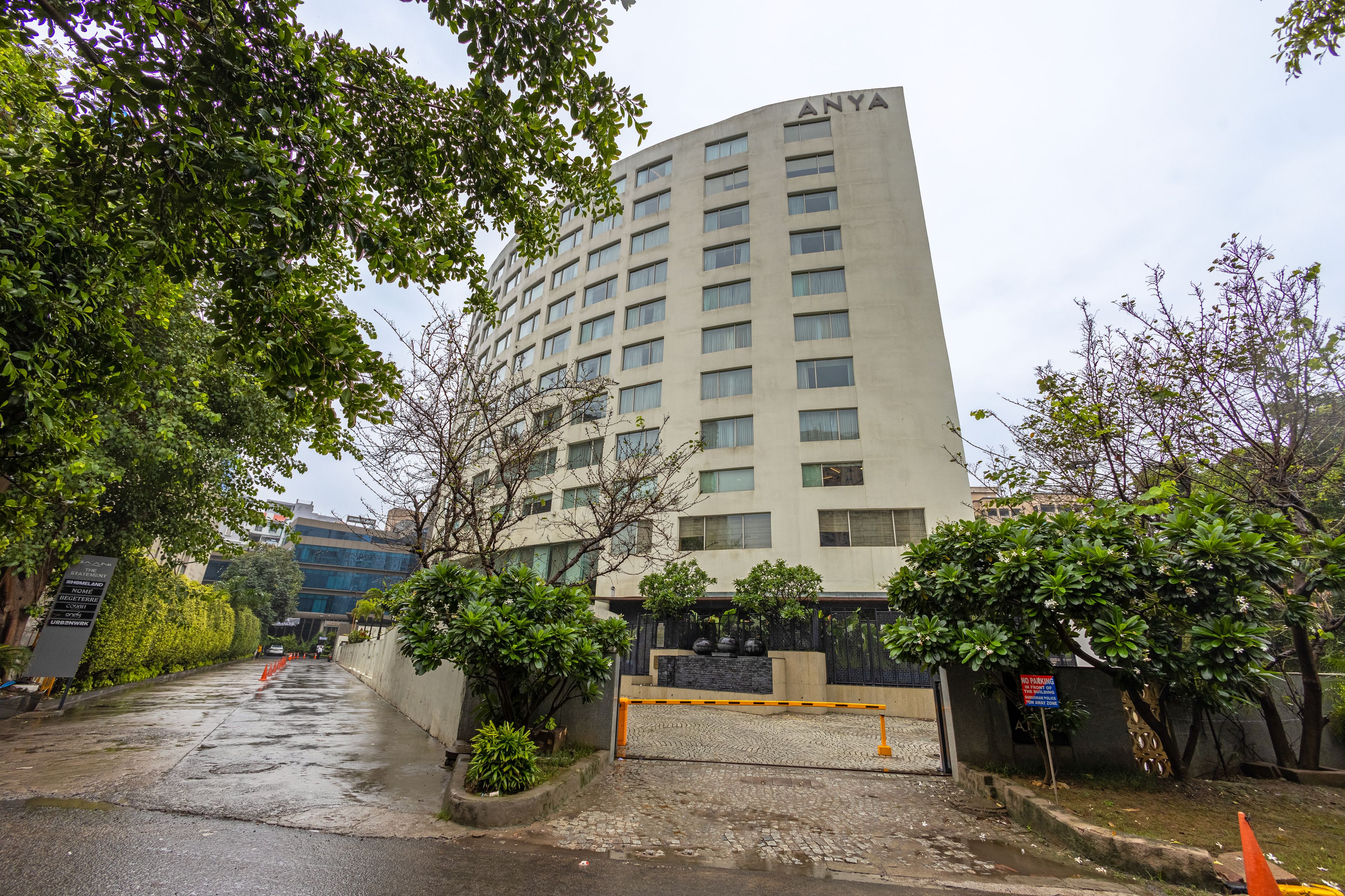 A multi-story building with a flat facade, a gated entrance, and a paved driveway.