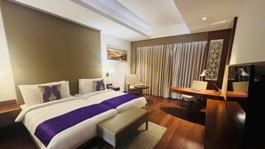 A modern hotel room with a large bed, a desk, and a TV. - The Anya Hotel, Gurgaon (Gurugram)