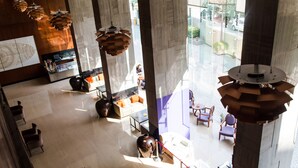 A spacious lobby with high ceilings, modern furniture, and large windows allowing natural light. - The Anya Hotel, Gurgaon (Gurugram)