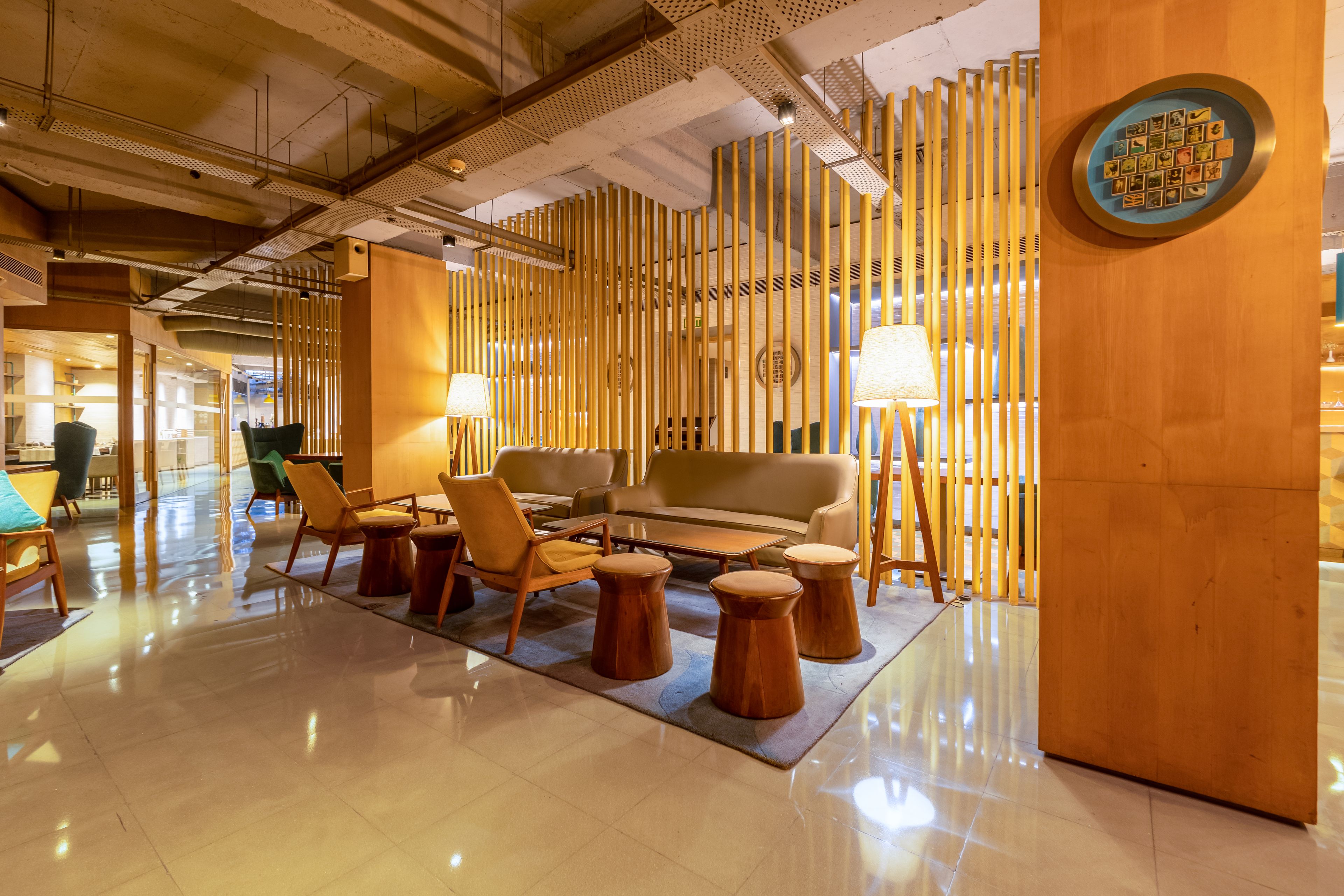 A modern lobby with a seating area, a sofa, and a decorative wall with vertical elements.