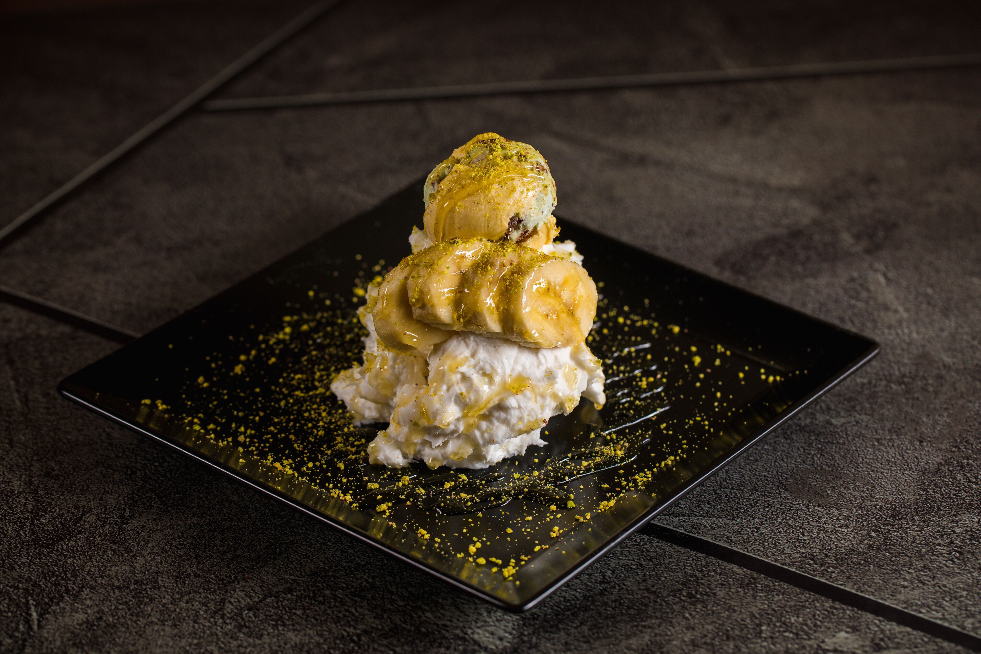 Un dessert servi dans une assiette carrée à la surface texturée.