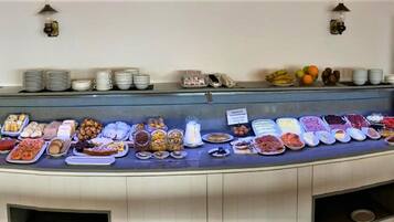 A buffet setup with various food items and a coffee machine.