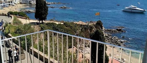A balcony with wicker furniture and a view of the sea.
