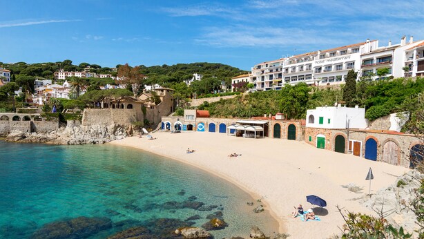 Un hotel frente al mar con playa, aguas cristalinas y arquitectura tradicional.