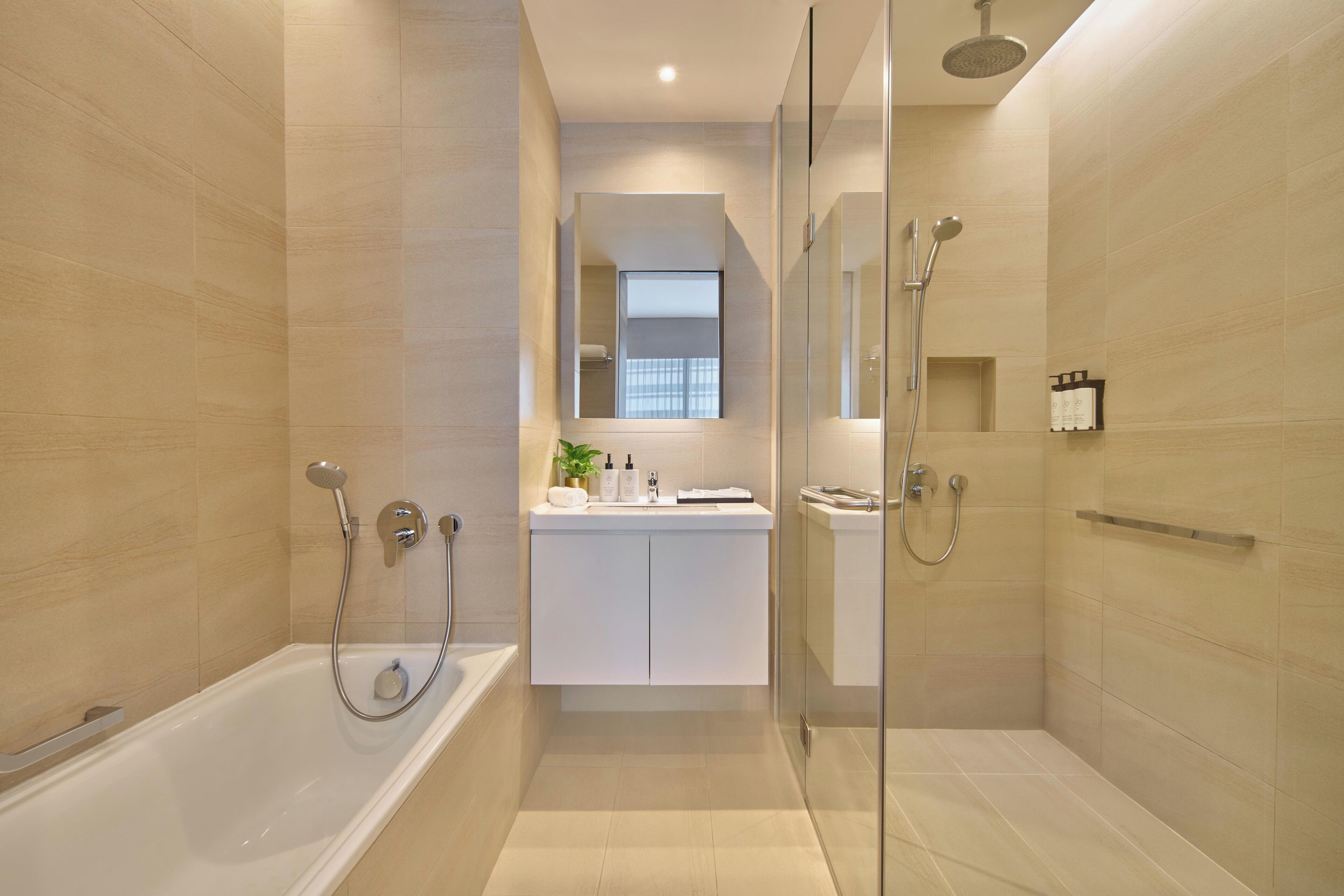 Een moderne badkamer met een bad, een douchegedeelte en een wastafel met spiegel.