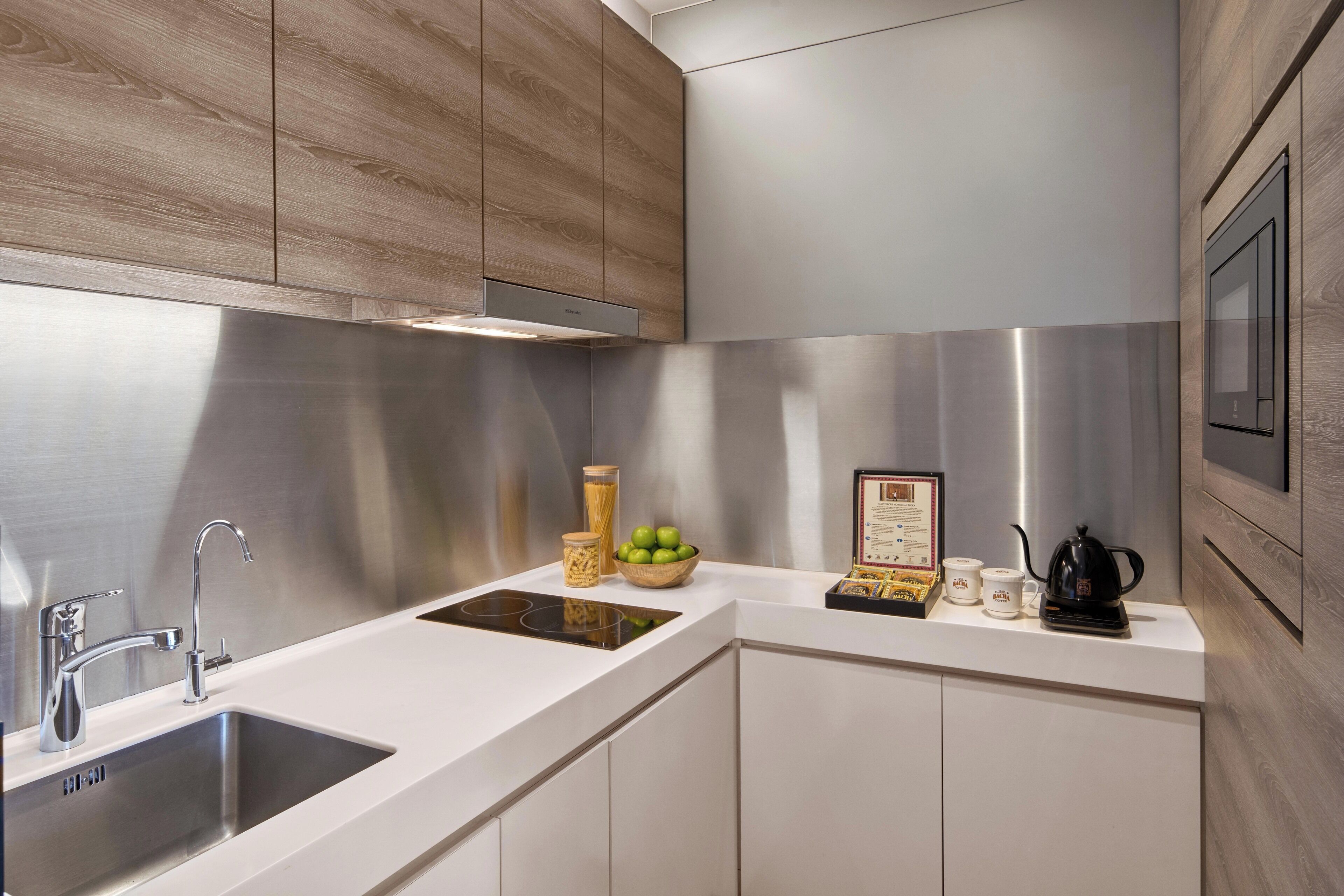 A modern kitchen with a stainless steel sink, a built-in stove, and wooden cabinetry.