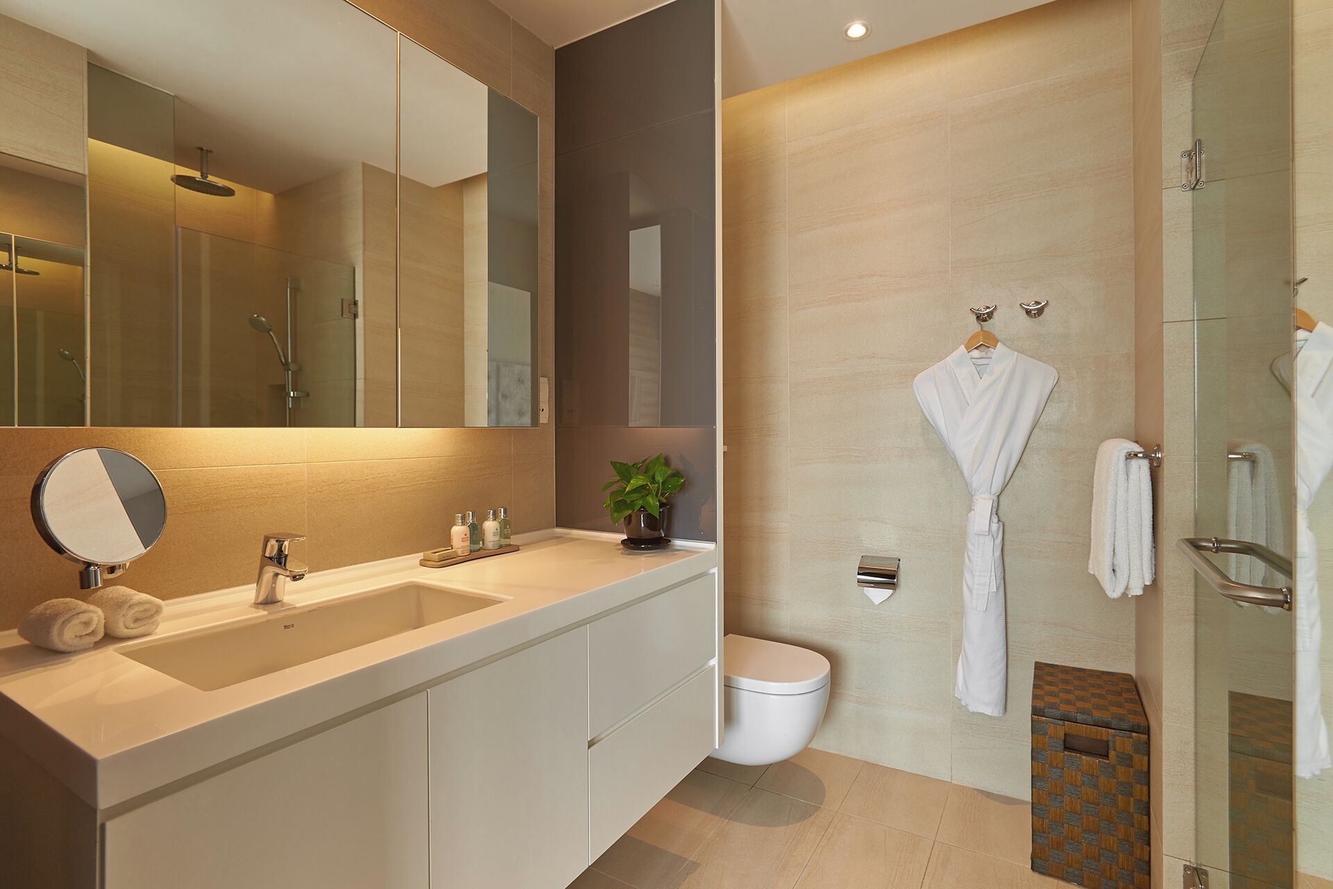 Een moderne badkamer met een grote spiegel, twee wastafels, een toilet en een douche.