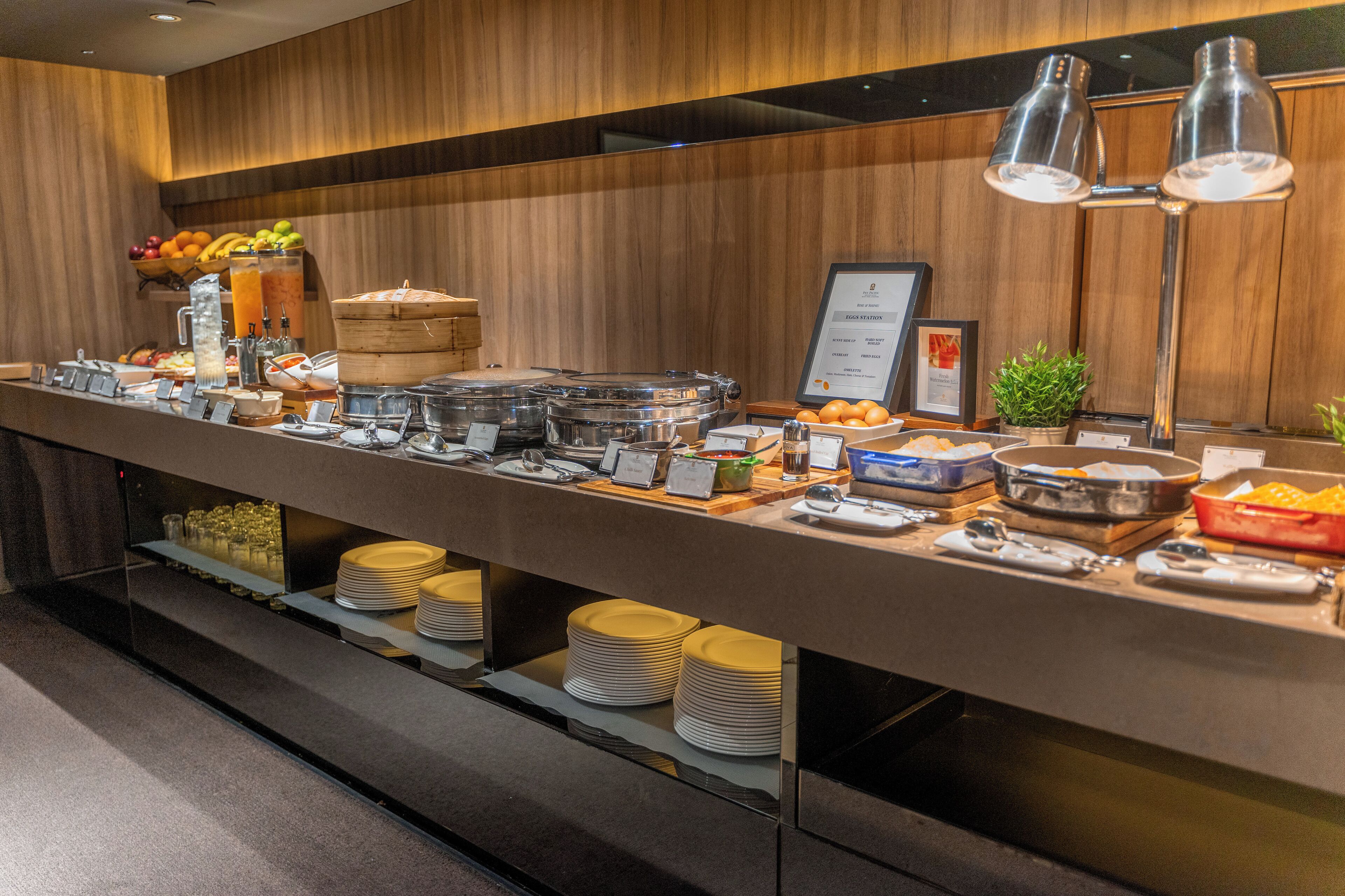 A buffet setup with various food items and serving utensils.