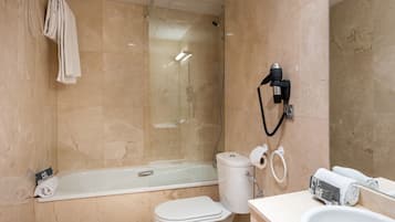 A bathroom with a bathtub, toilet, and sink.