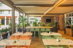 A restaurant with indoor seating, a bar area, and a reception desk.