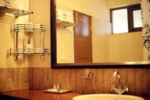 Une salle de bain avec un meuble-lavabo en bois, un grand miroir et un porte-serviettes en verre.