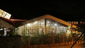 Un edificio moderno con amplios ventanales de vidrio y fachada de madera de noche.