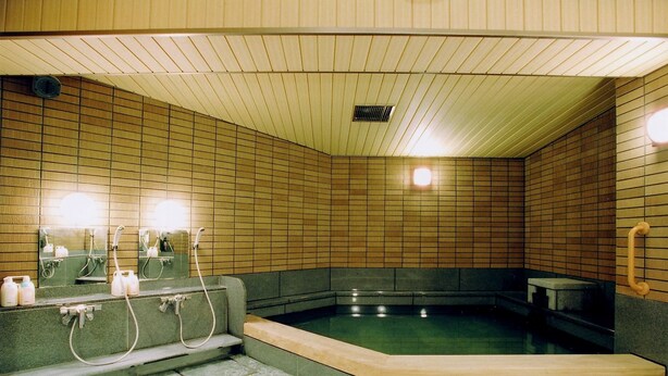 A sauna room with a wooden ceiling, tiled walls, a bench, and a small pool. - Kamogawa-kan Inn (Kyoto)