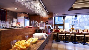A breakfast bar with a wooden counter, a bowl of fruit, and a coffee station. - NINE TREE BY PARNAS SEOUL MYEONDONG 1 (Seoul)