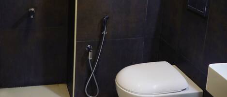 Une salle de bain moderne équipée de toilettes, d’une douche et d’une fenêtre.