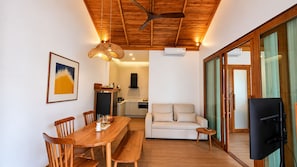 A modern interior with a dining area, sofa, and kitchenette. -  Kirivara Suite & Wellness (Krabi)