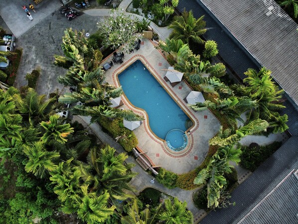An aerial view of a swimming pool surrounded by lush greenery and palm trees. - Phuvara Boutique (Krabi)