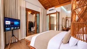 A hotel room with a bed, a television displaying streaming services, a wardrobe, and a mirror. -  Kirivara Suite & Wellness (Krabi)